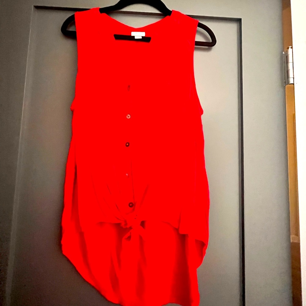 Red sleeveless top, ties in the front, hangs low on the back